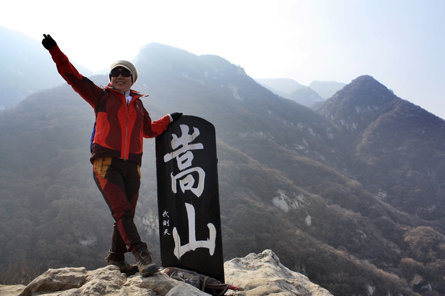 중악 숭산 봉황대 정상에서 한 등산객이 손을 들어보이며 기념사진을 찍고 있다. 뒤에 보이는 산이 정상연천봉. 