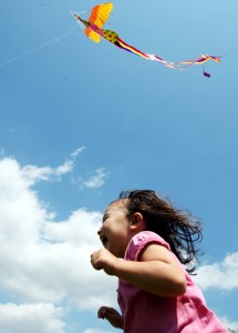 연을 날리며 달리고 있는 어린이.